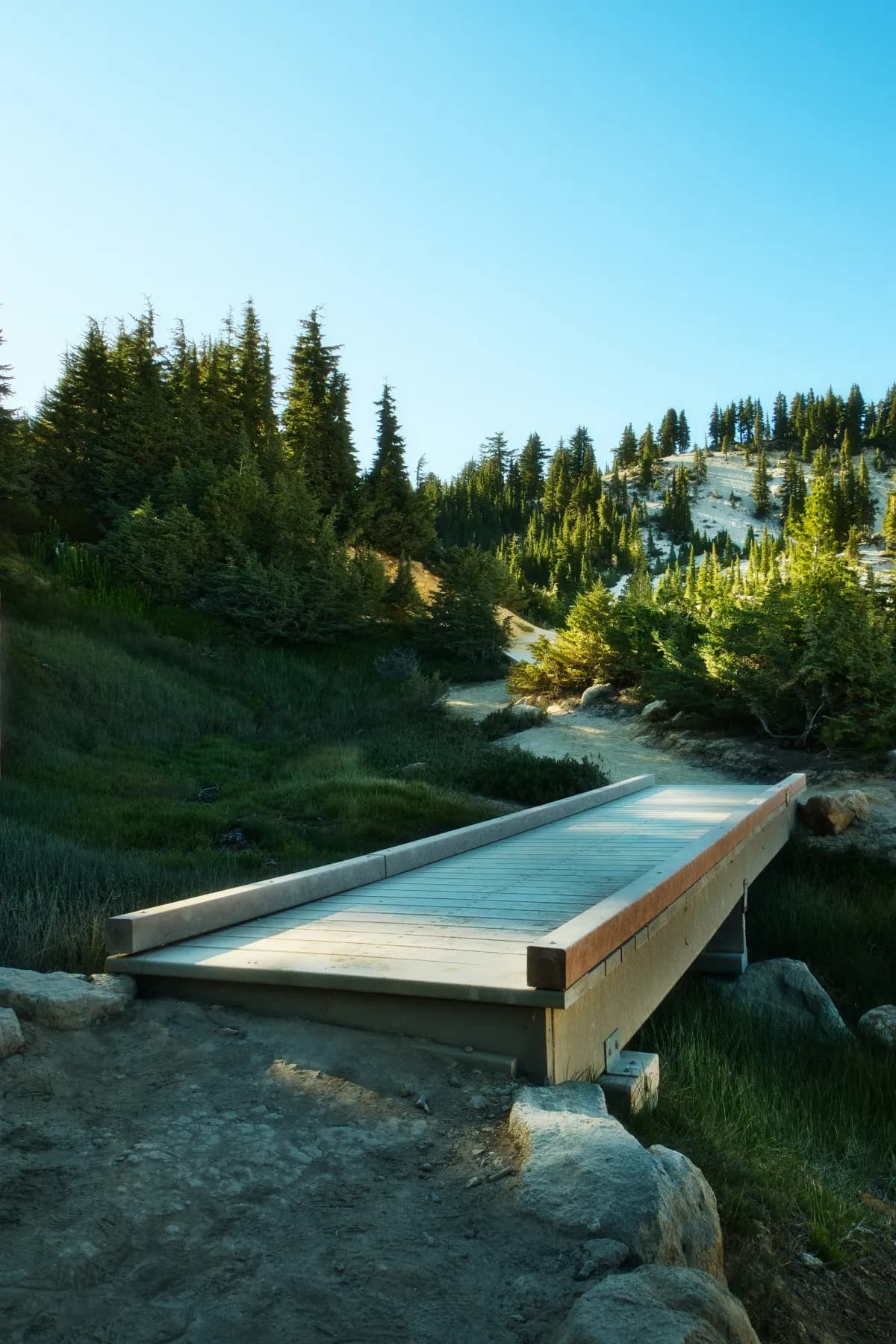 A stone bridge crossing a mountain stream — passage built to endure.